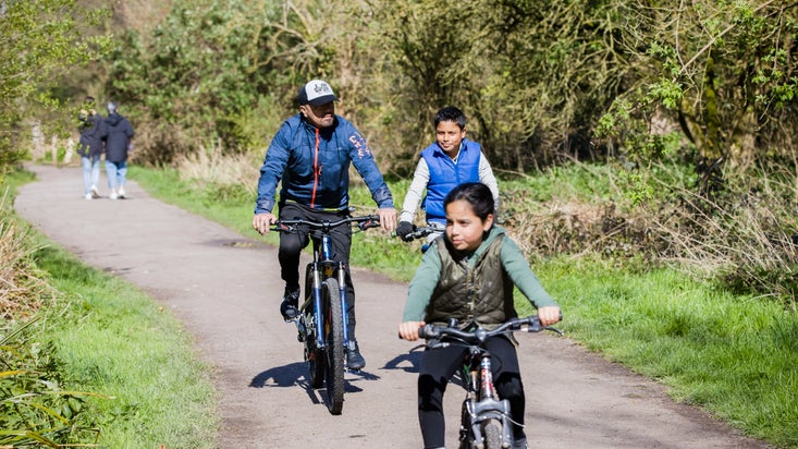 A family on a bike ride at Morden Hall Park, London